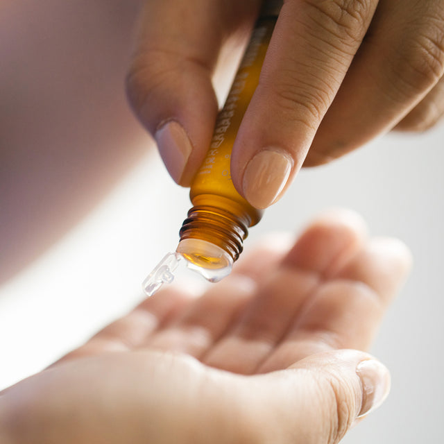 person dropping essential oils from Brainstrom roll-on